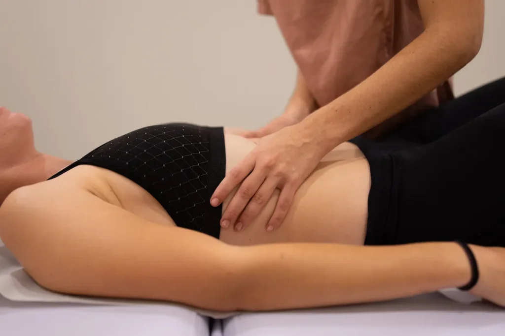 Fisioterapeuta realizando terapia manual en la zona abdominal durante una sesión de fisioterapia del suelo pélvico
